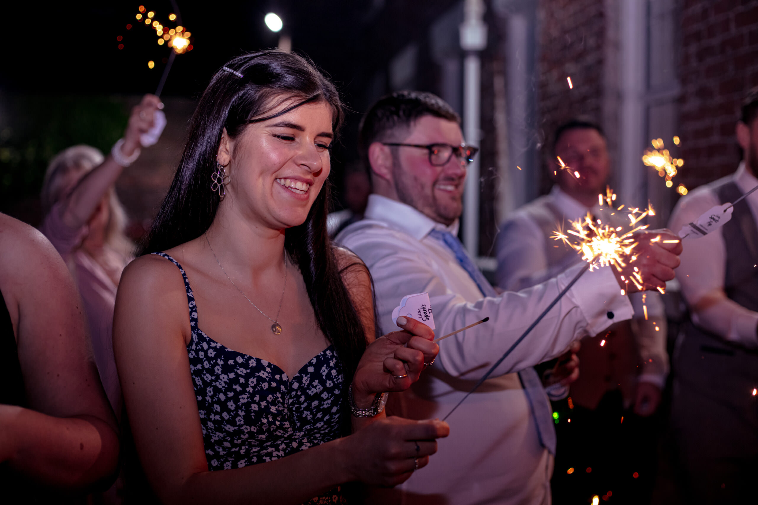 Guests light sparklers outside during the evening reception.